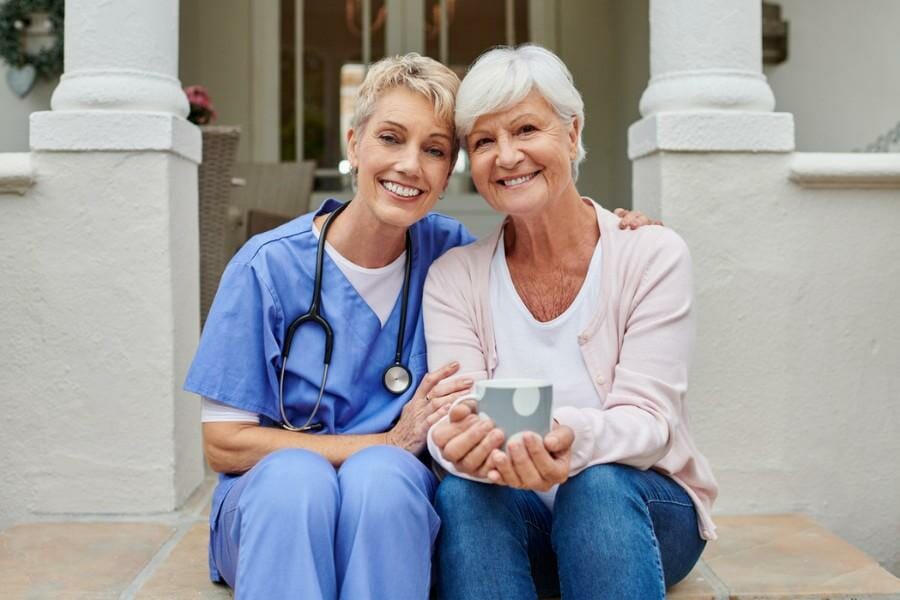 A smiling at home concierge nurse and patient