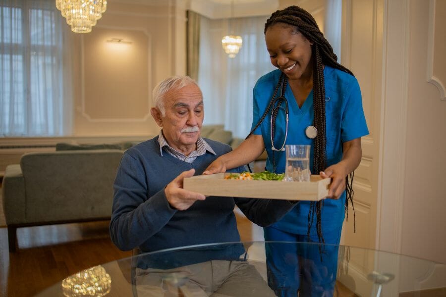 private duty nurse helping her client eat.