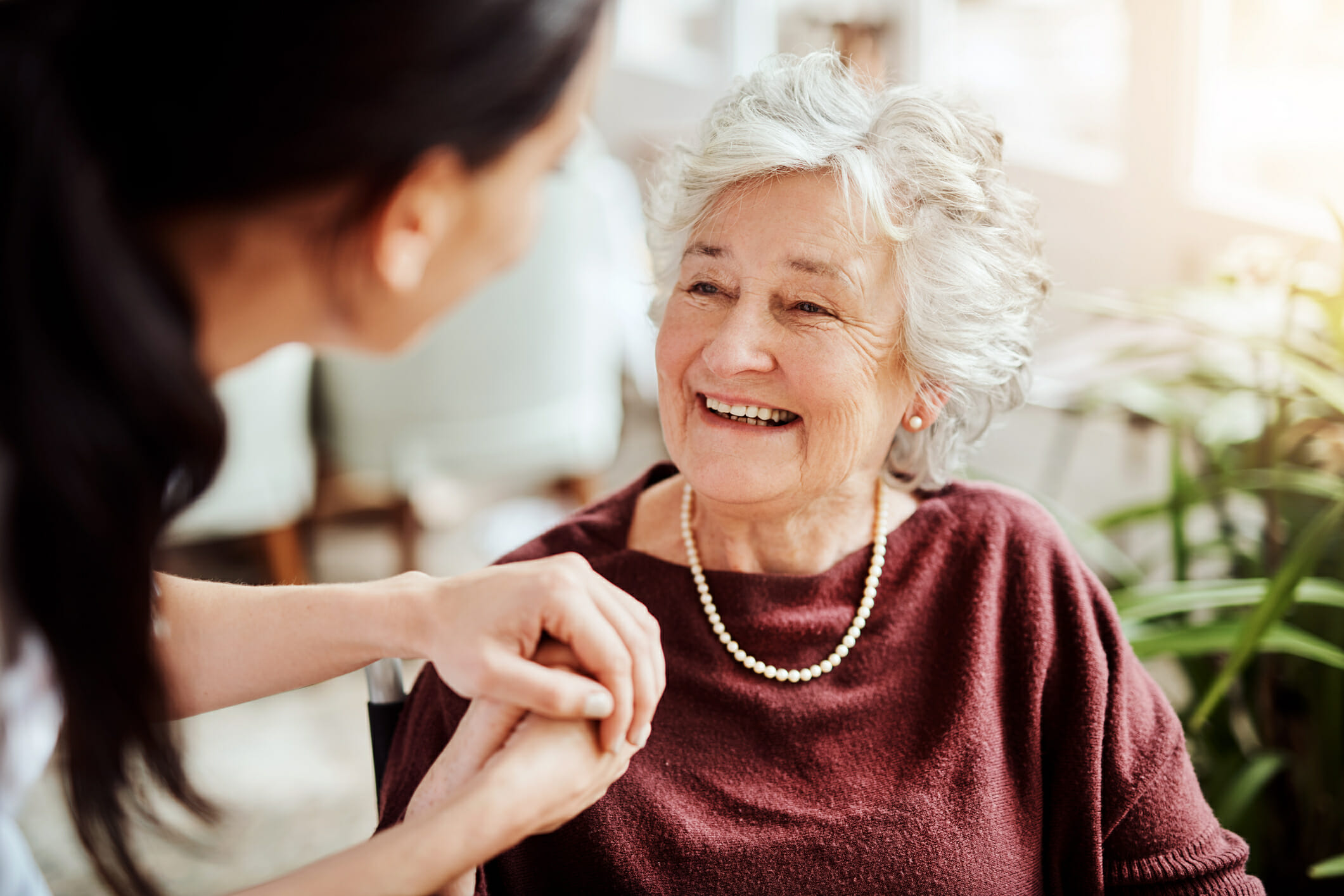 senior woman smiling with nurse at home