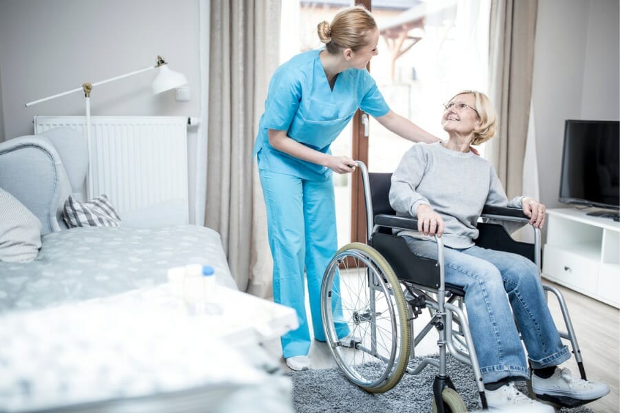 home health aid assisting patient in wheel chair.