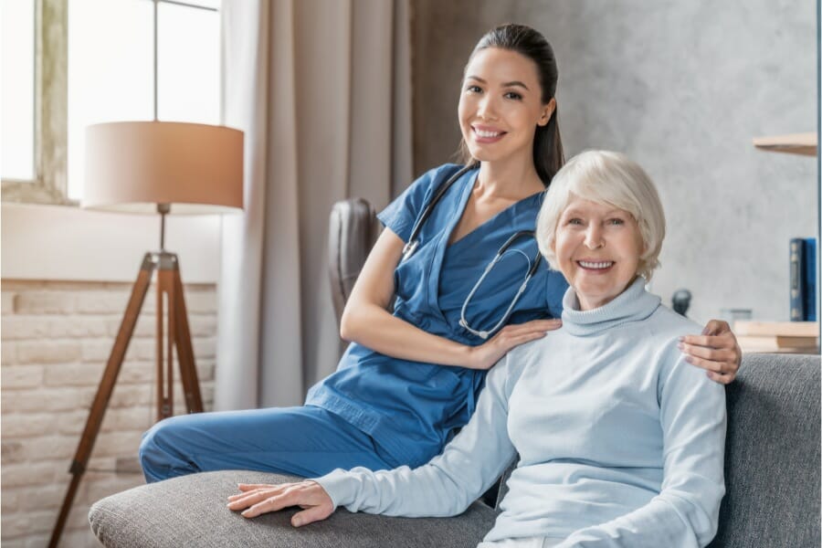 An in home nurse smiling with her happy and healthy patient.