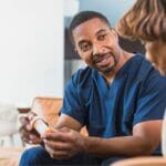 A private duty nurse offering medication management to his patient.