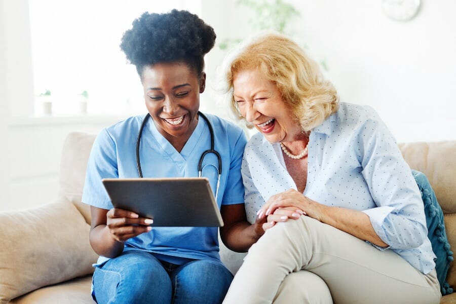 home health care nurse laughing with her patient
