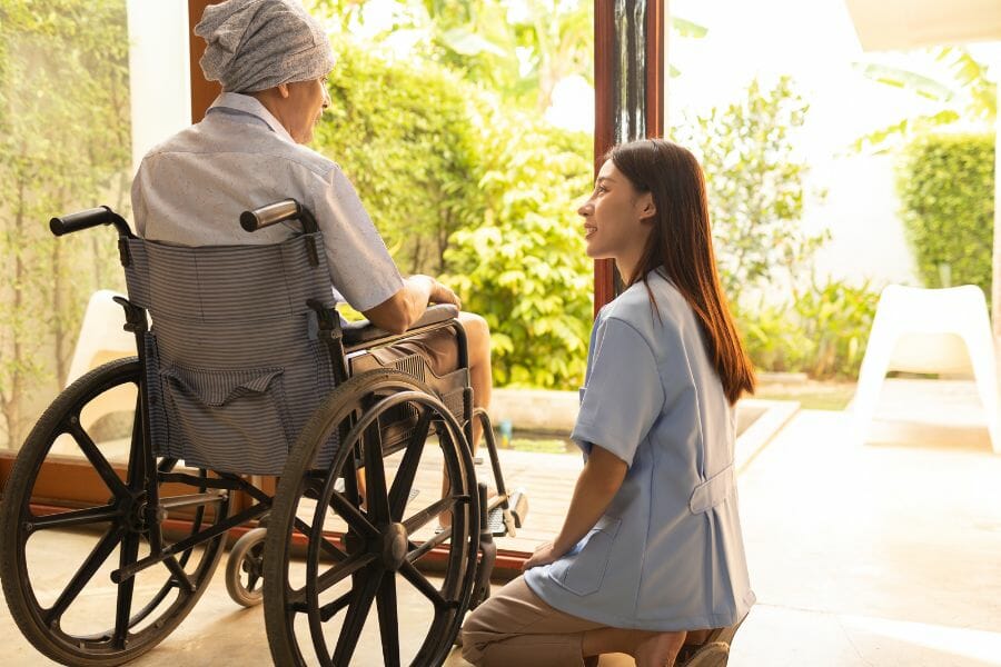 An in home nurse assisting their client in a wheel chair.
