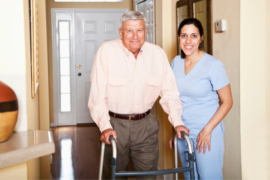 a patient using a walker and a home health aid