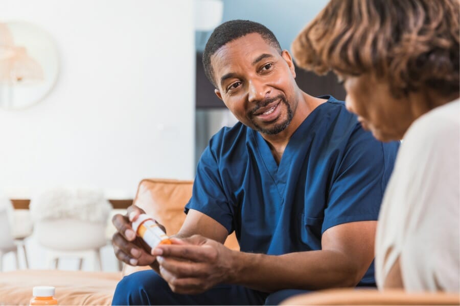 local male in home nurse discussing medication management.