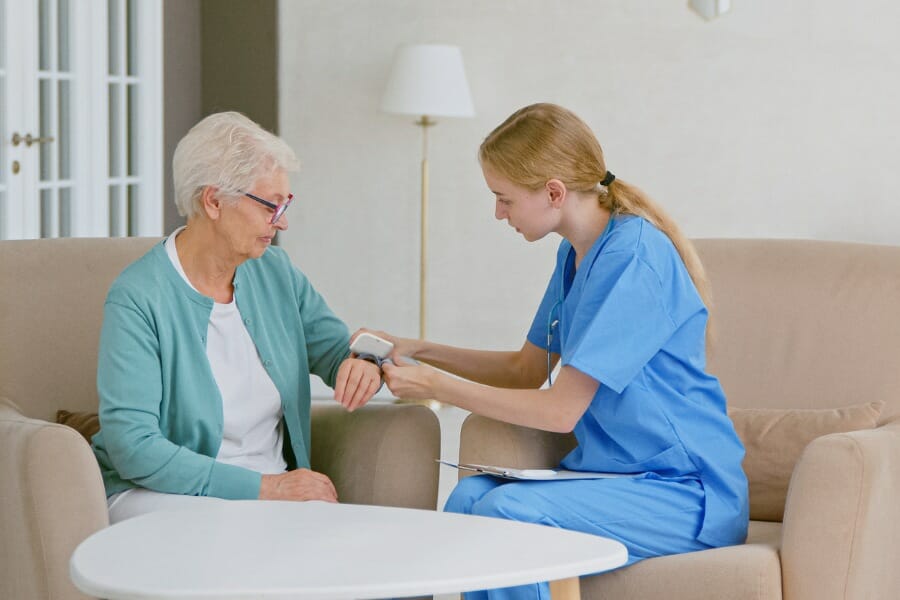 An in home nurse assisting her elderly patient.