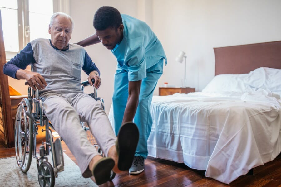 a senior citizen in a wheel chair with his private duty nurse.