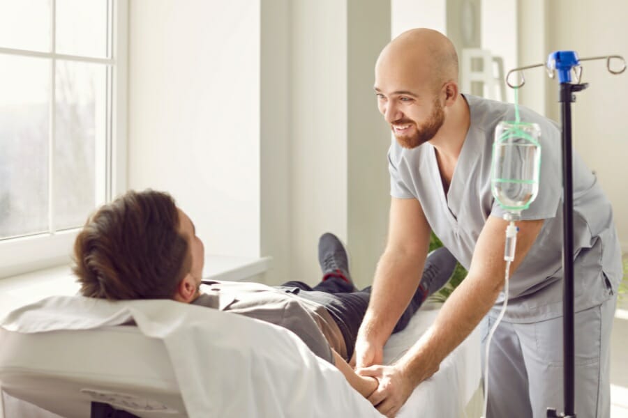 An RN assisting a patient.