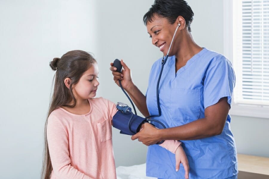 A smiling nurse and her young patient.