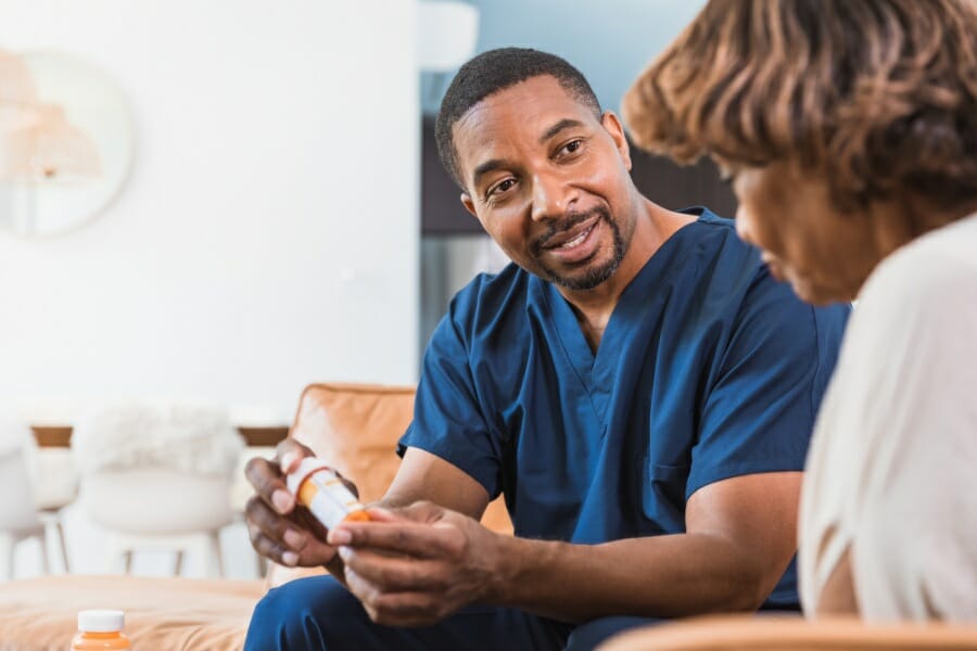 An RN providing medication management for a senior patient.