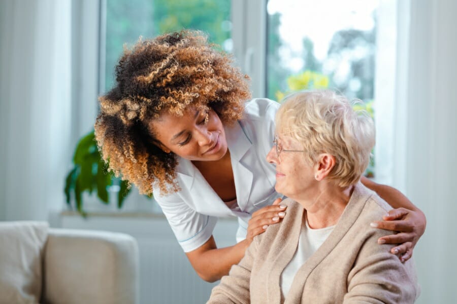 Registered nurse assisting her senior patient.