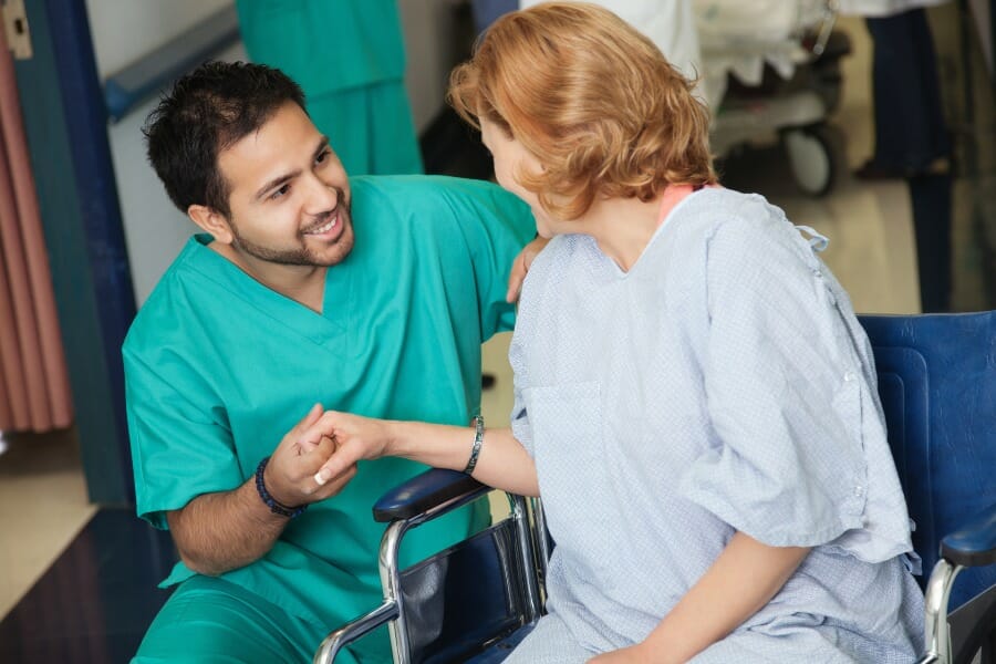 Local nurse assisting a patient in a wheelchair