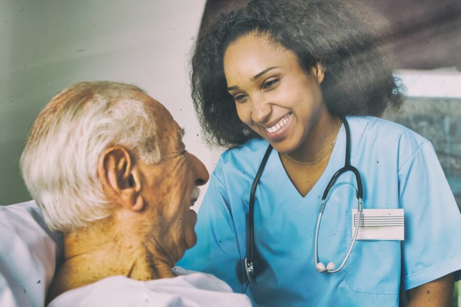 RN smiling with her elderly patient.