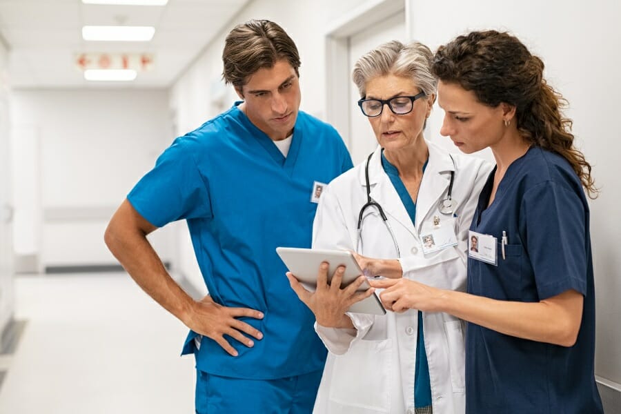 Nurses and a doctor discussing a patient's chart.