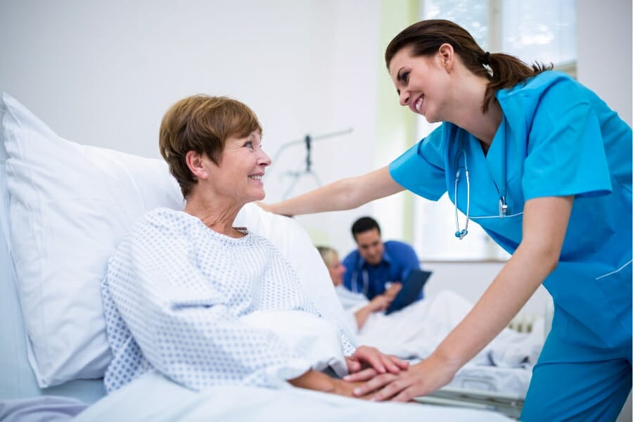 An RN offering a reassuring smile to a patient at a skilled nursing facility