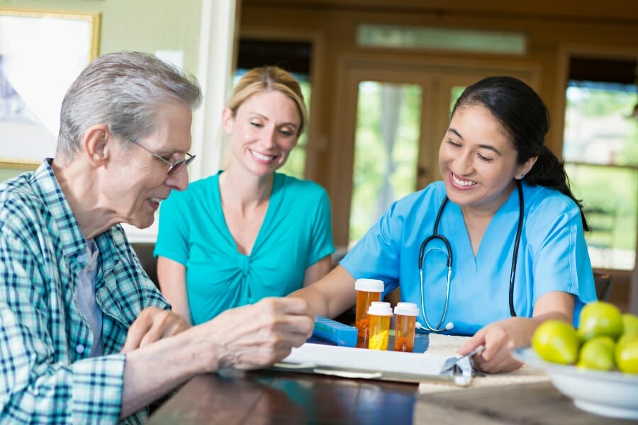 two home caregivers and an elderly patient