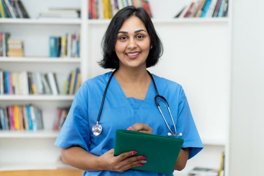 nurse holding a patient's chart and smiling