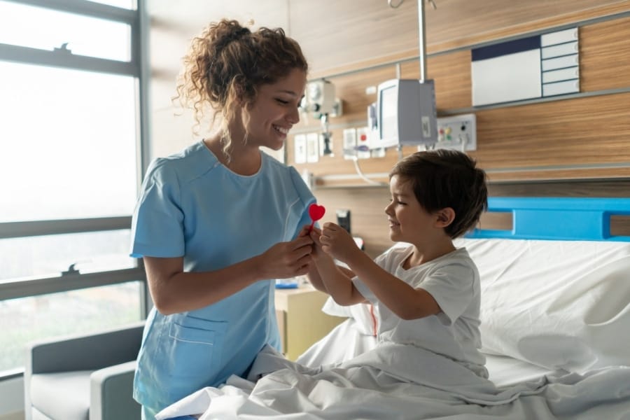 A smiling pediatric nurse with a young patient
