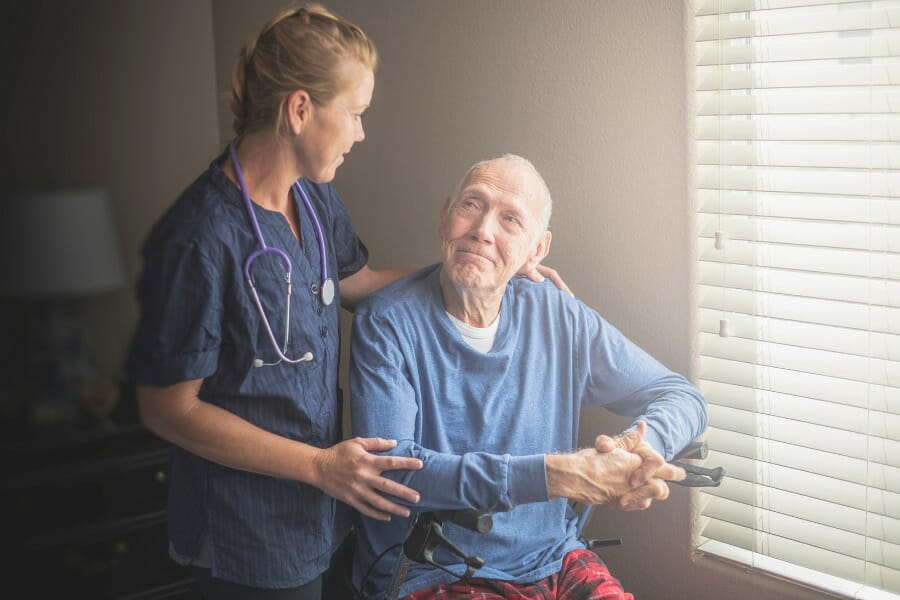 Patient with early on-set dementia smiling at his in-home nurse
