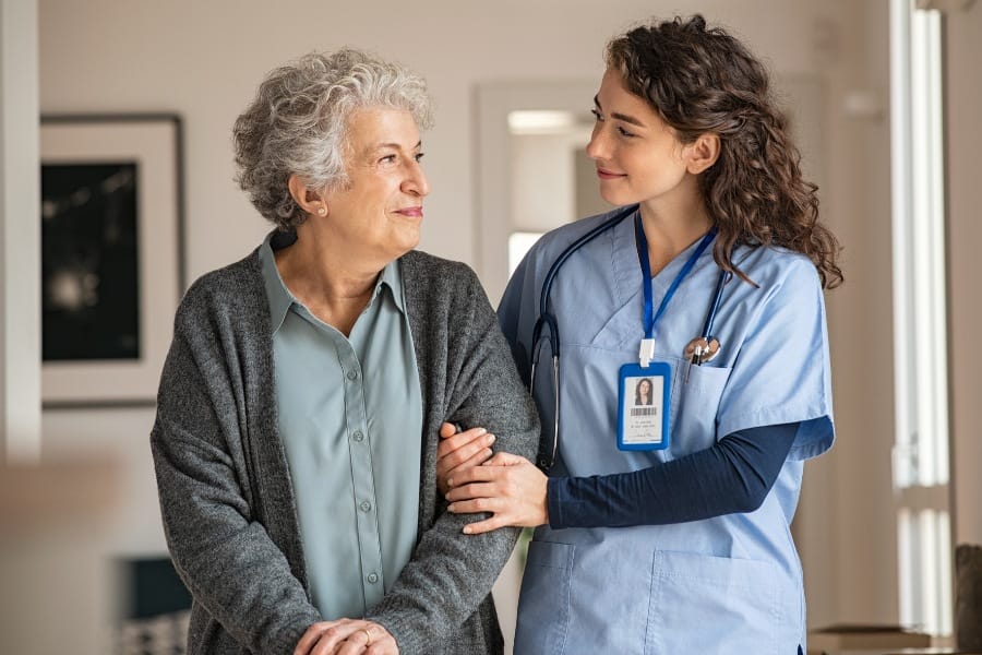 An RN assisting an elderly woman walking