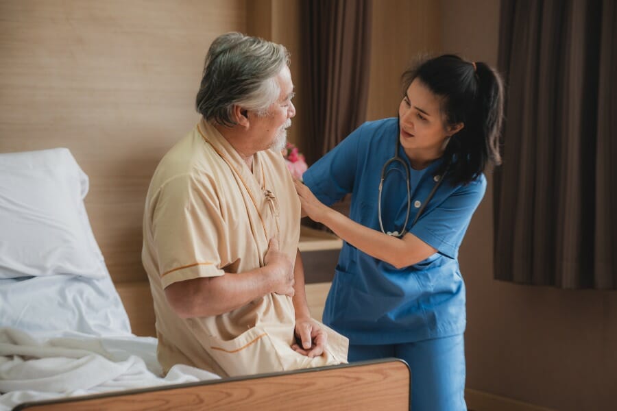 RN assisting her client get out of bed