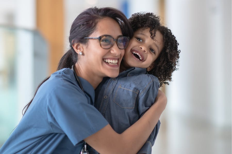 A young patient laughing with her at home nurse