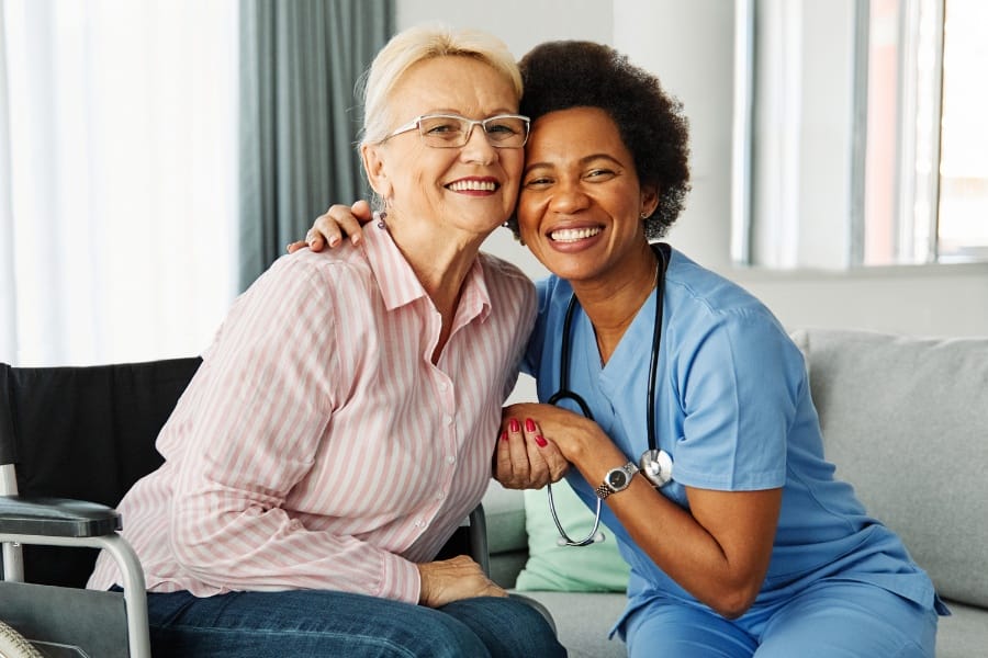 Private duty nurse and elderly patient smiling