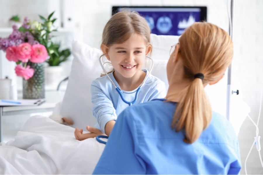 Pediatric nurse letting a young patient play with her stethoscope