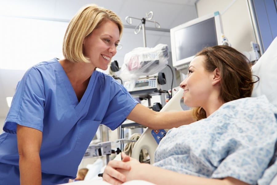 Smiling LVN assisting a woman