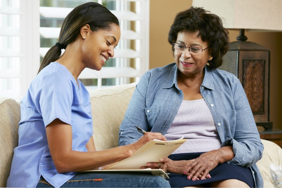 Nurse updating a patient's record in their home