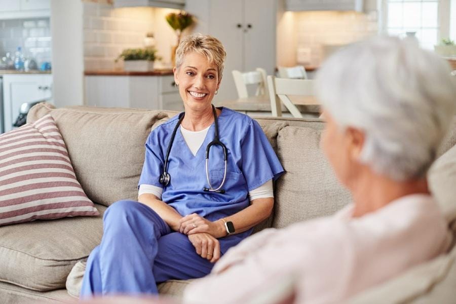 in home nurse sitting with her patient in California