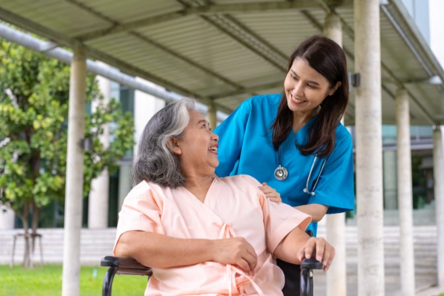 A patient in a wheel chair and her in home private nurse
