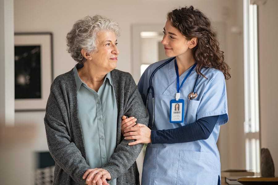 A private nurse assisting an elderly patient in their home