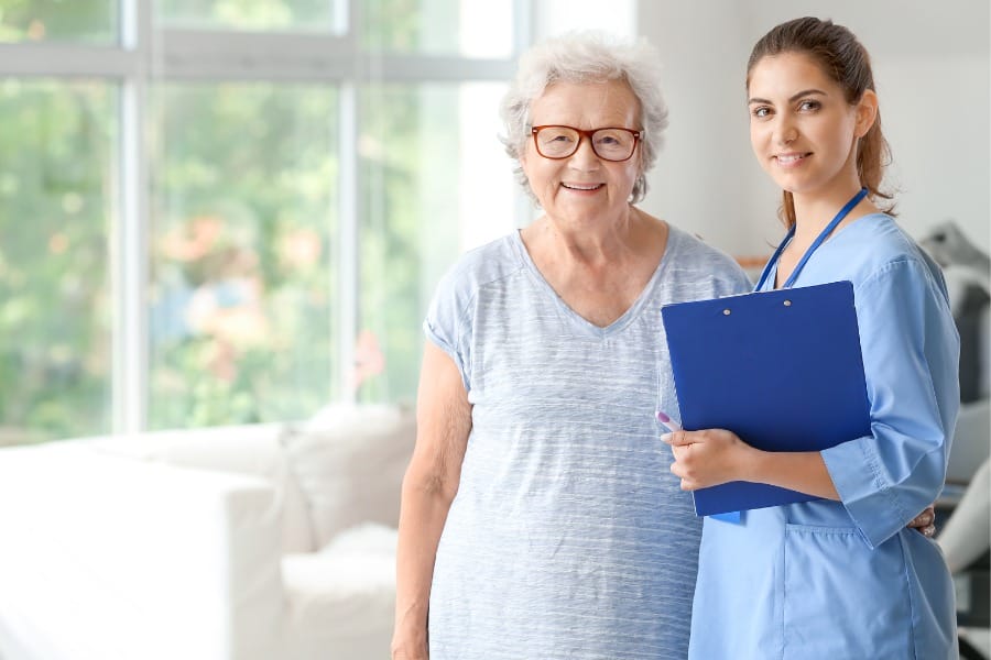 A smiling home health nurse and her patient