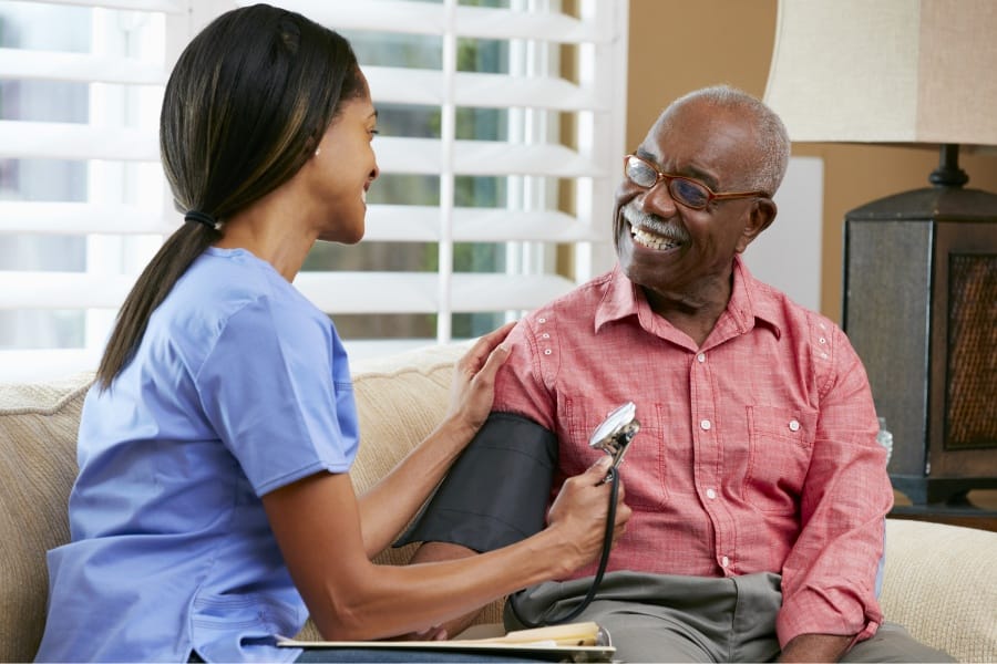 Loyola, California in home nurse checking a patient's bloodpressure