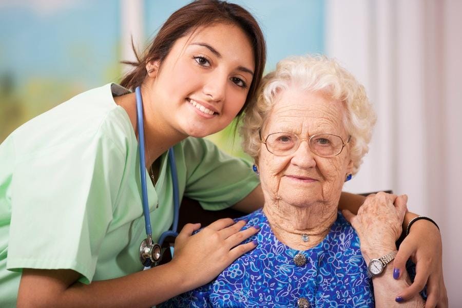 A private in home nurse and her senior client smiling