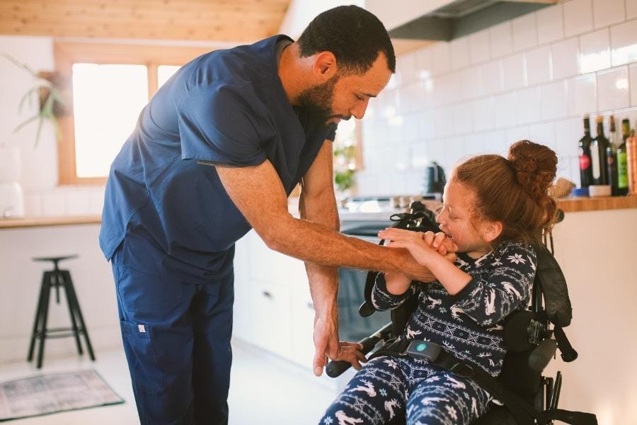 A pediatric nurse helping his young patient