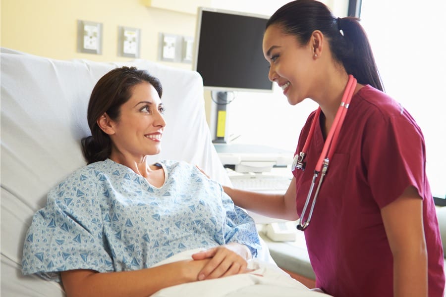 A nurse with her patient in bed