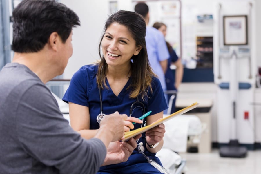 nurse helping a patient with his charts