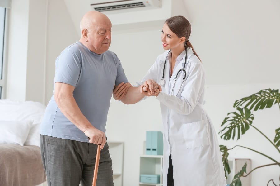 A man with PD using a cane for mobility