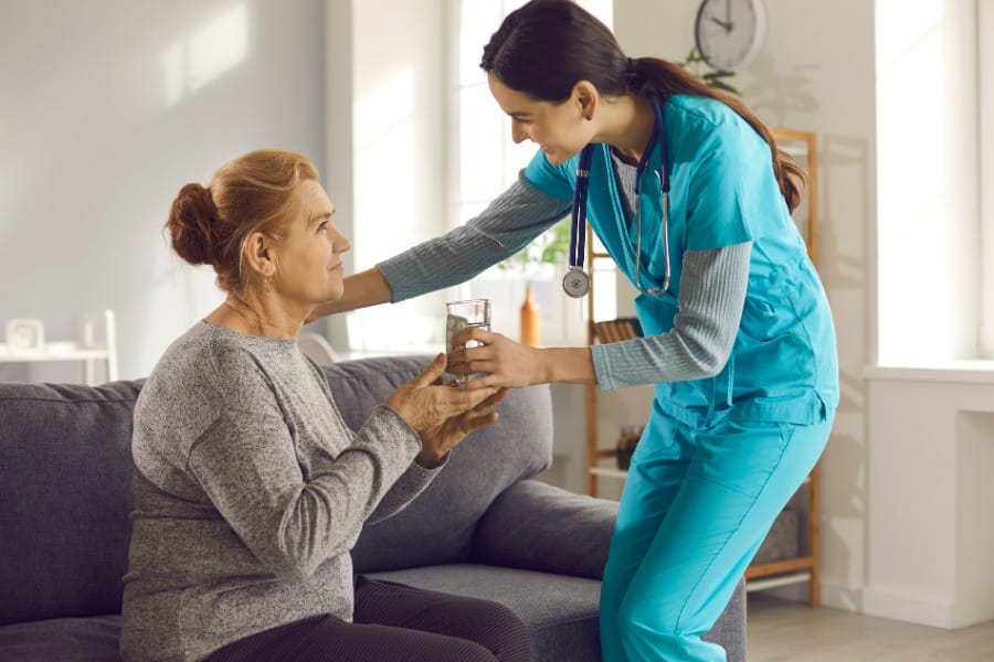 nurse helping a PD patient take their medication