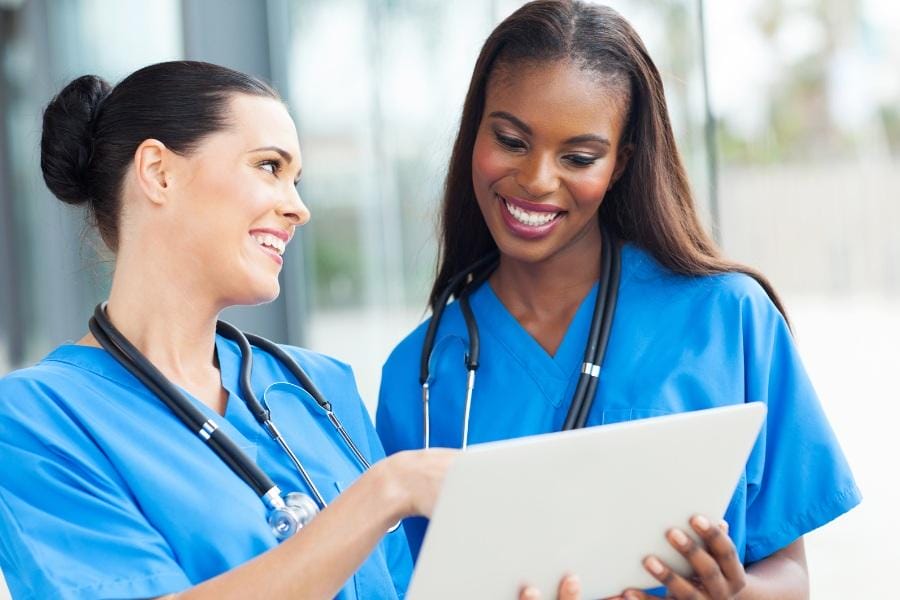 happy nurses talking about a patient's chart