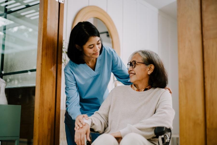 In-home nurse helping her client in a wheelchair