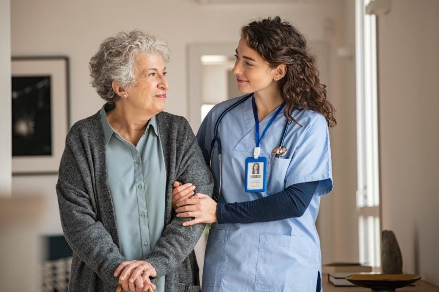 at home nurse assisting her elderly client