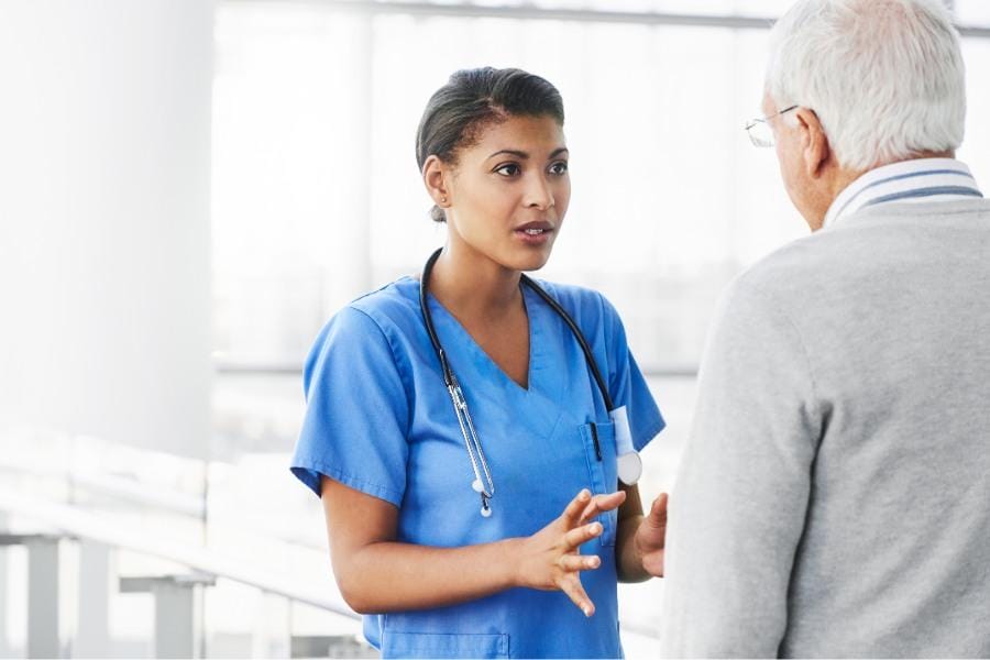 Elderly patient talking to his nurse regarding an upcoming procedure