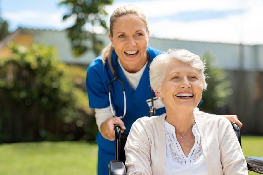 home nurse pushing her client in a wheelchair