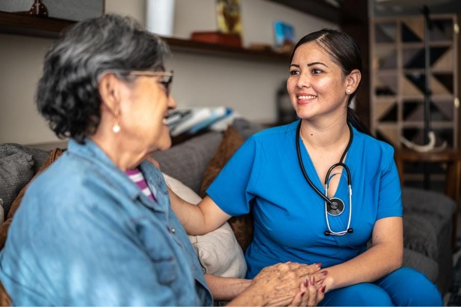 A smiling nurse and her elderly client